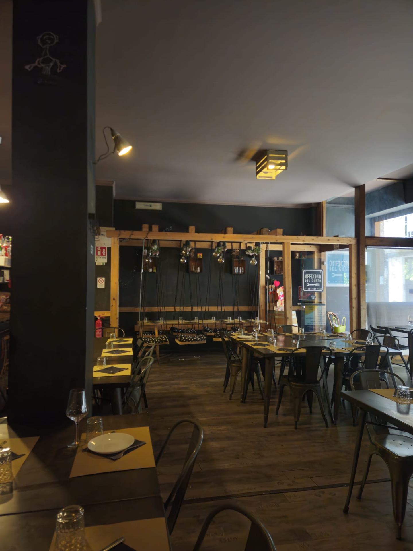 La sala interna con tavoli e bancone in legno
